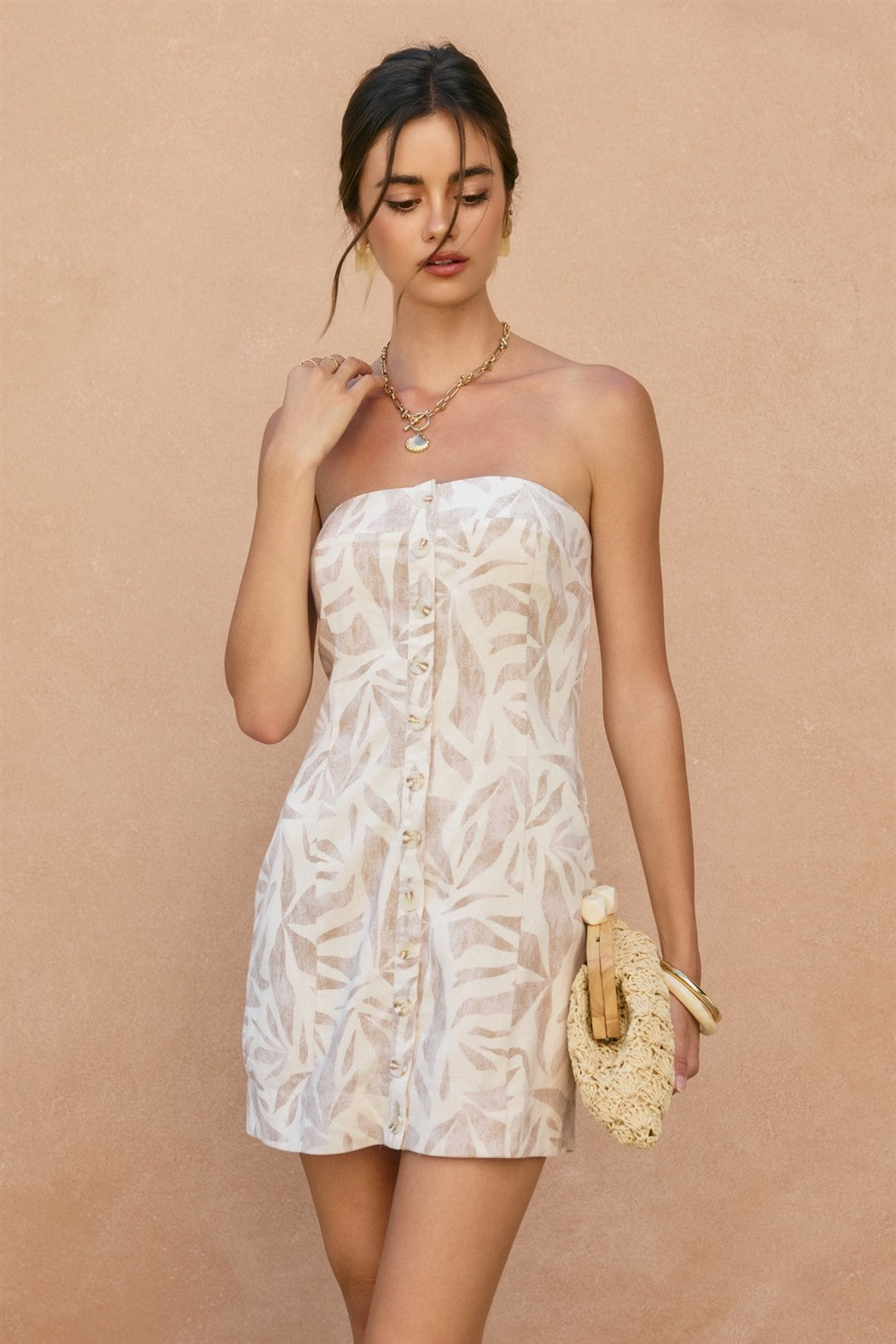 Woman wearing a strapless floral dress against a beige background