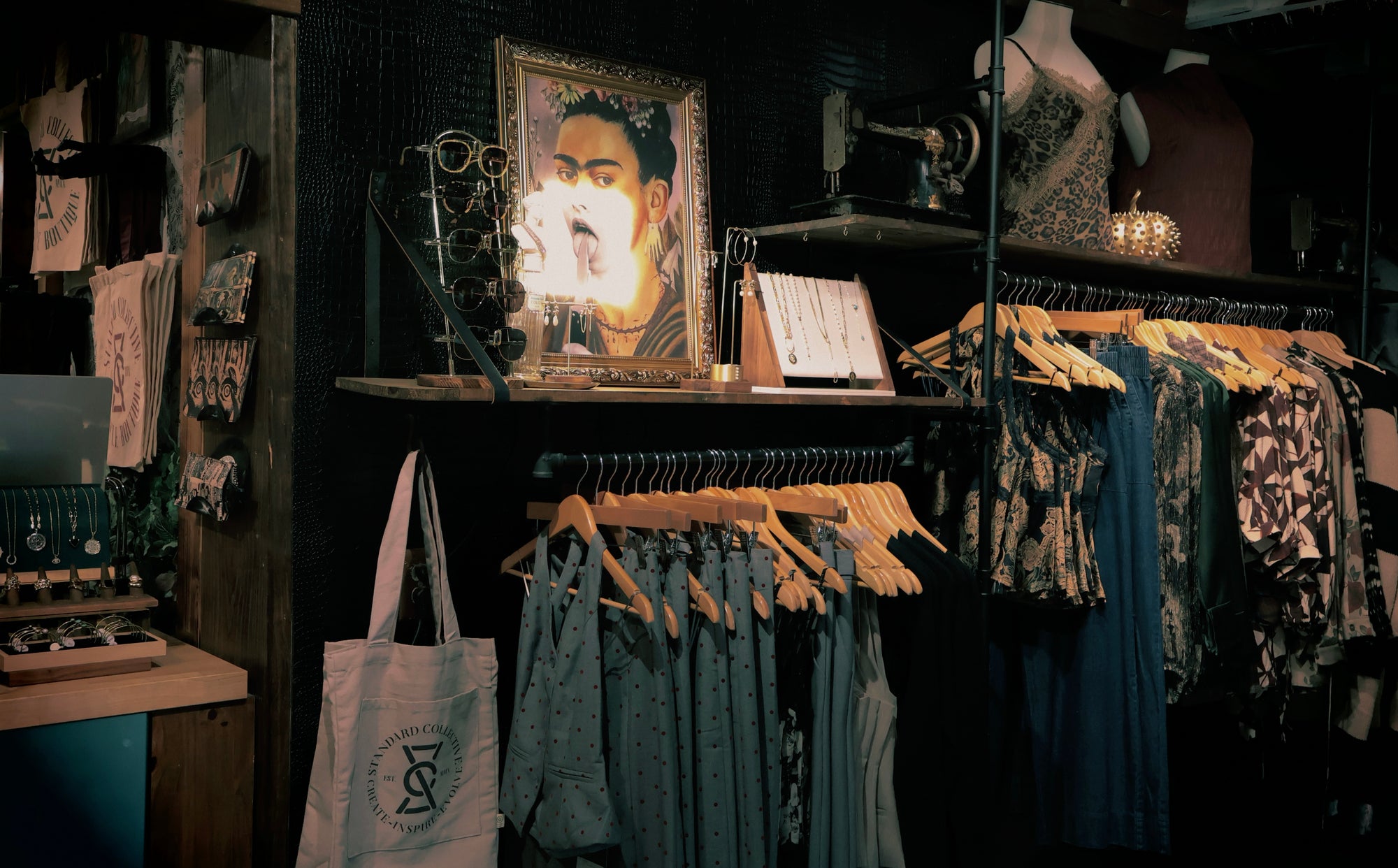 Clothing store interior with racks of clothes and a portrait on a shelf.