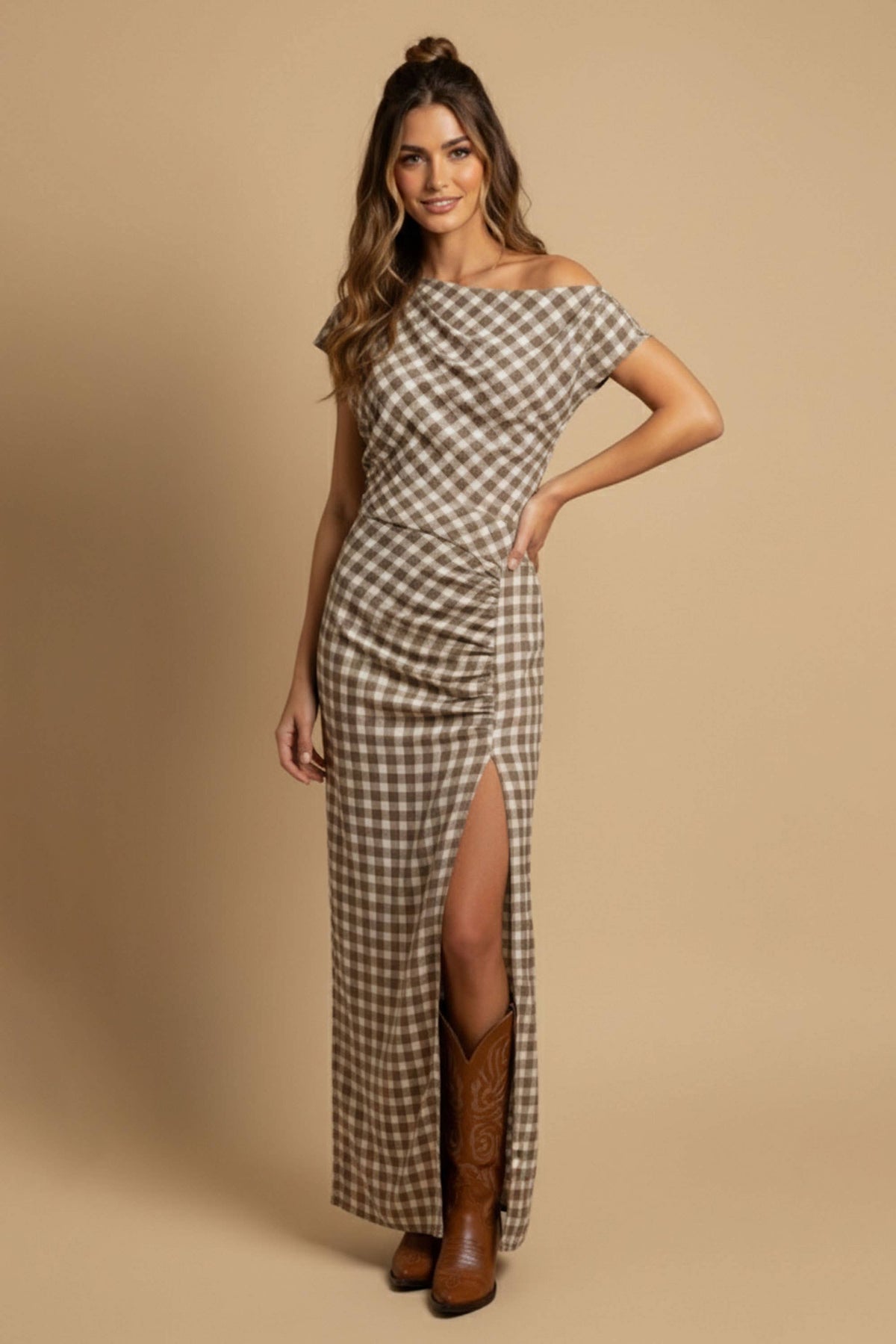 Woman wearing a plaid dress with a slit on a beige background
