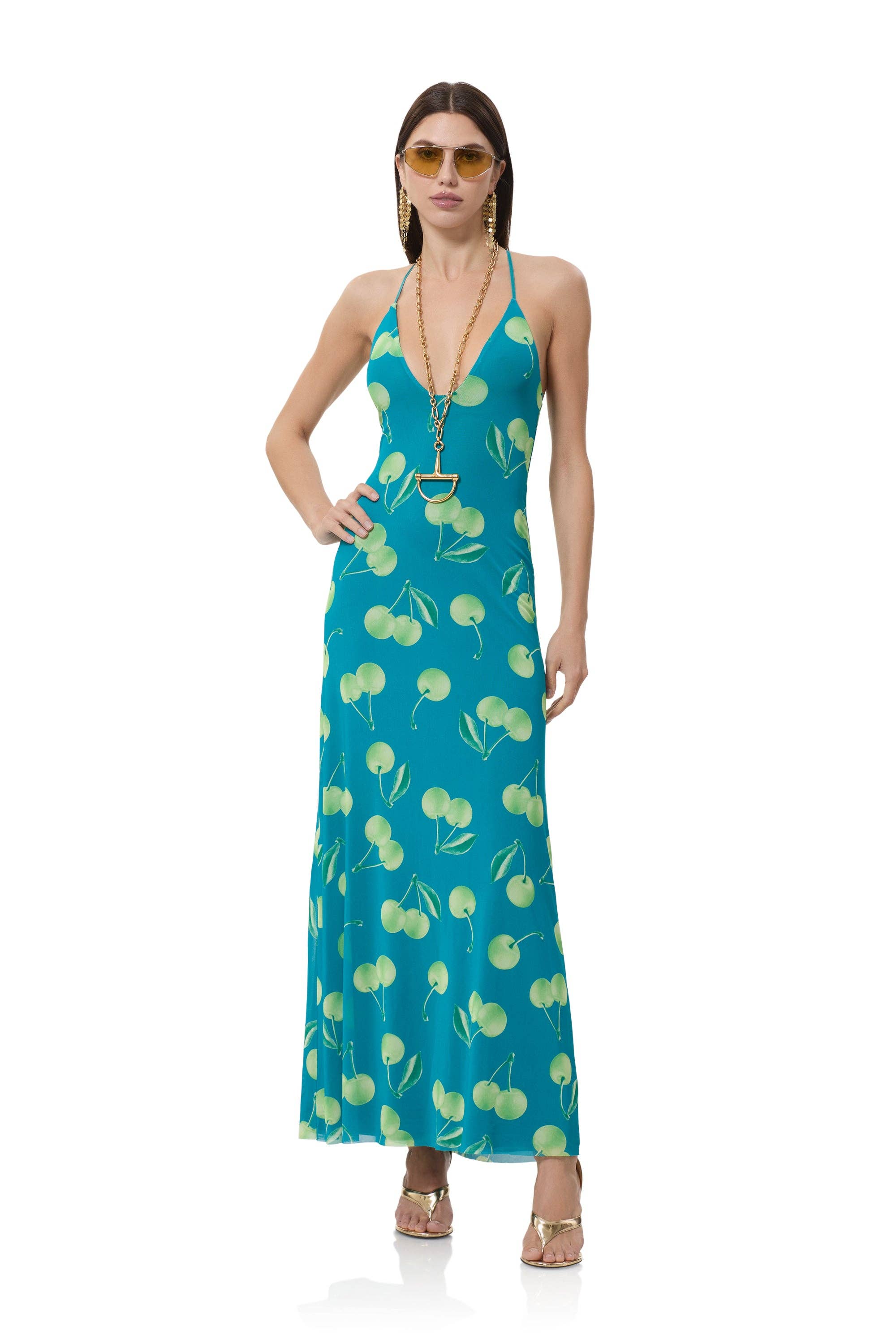 Woman wearing a teal dress with a floral pattern on a white background cherry prints all over AFRM