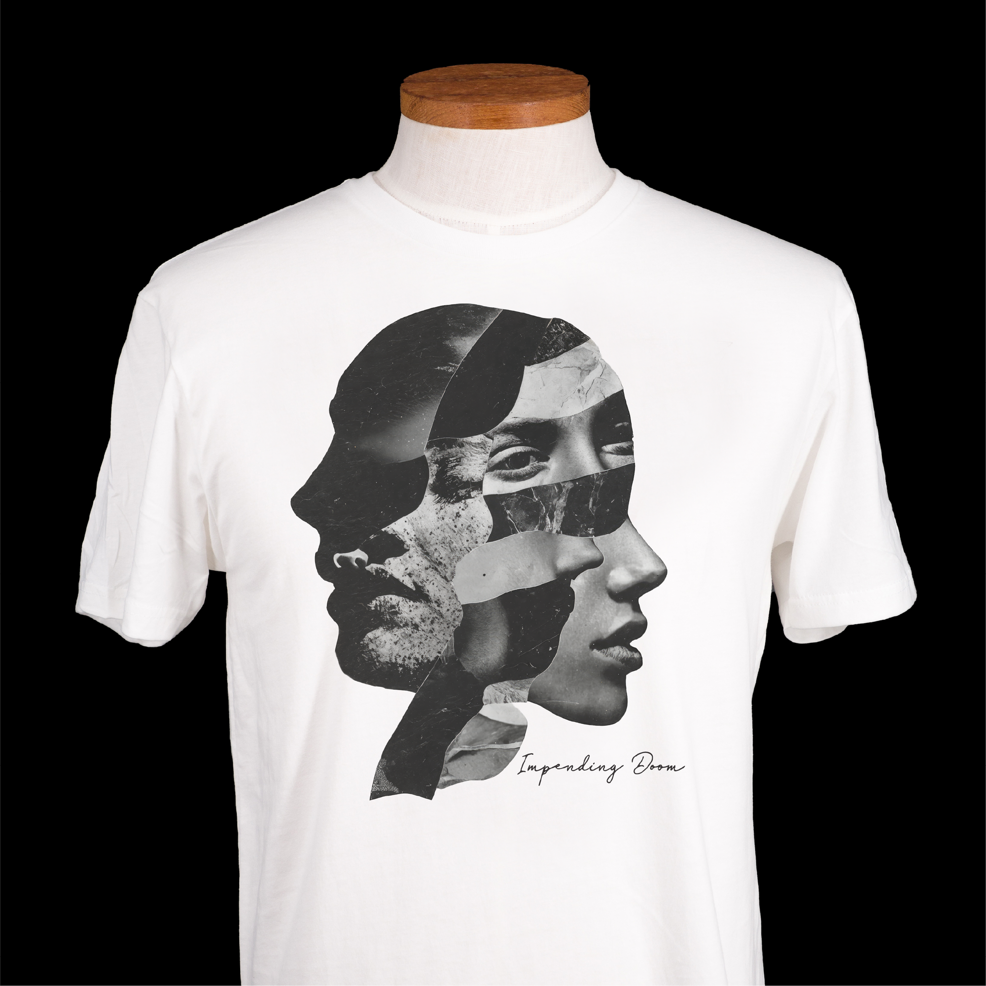 A white short-sleeve crewneck t-shirt displayed on a mannequin torso against a solid black background. The shirt features a large black and white graphic collage of multiple human profiles on the front, with the text 'Impending Doom' printed in black script below.