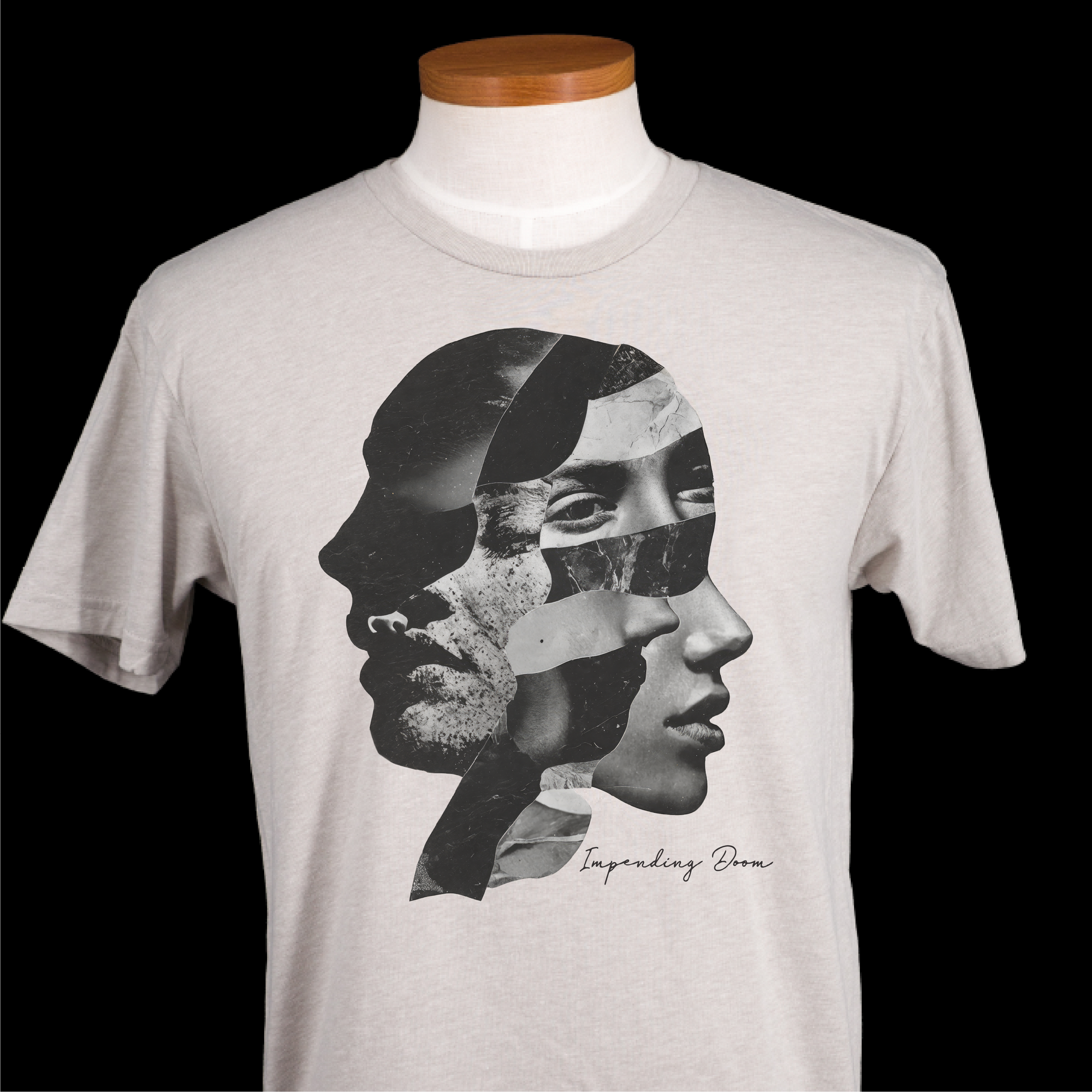 A light gray crewneck t-shirt displayed on a white mannequin torso with a wooden neck cap, featuring a black and white graphic collage of two faces and the text 'Impending Doom' on the front, set against a solid black background.
